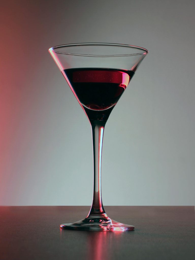 A sophisticated single glass of rich red wine in a chic setting.